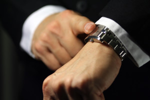 A businessman looking at his watch, deadline/due theme